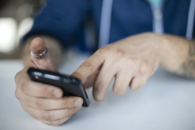 Akıllı telefonu olan genç bir adam.