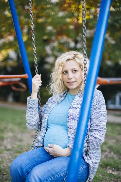 Zwangere vrouw op de schommel — Stockfoto