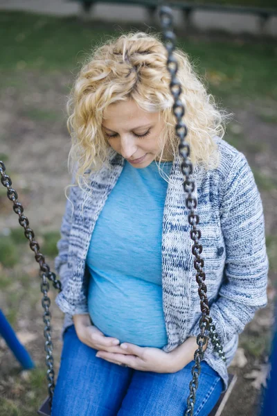 Pregnant woman on the swing — Stock Photo, Image