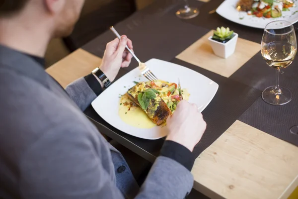 Man eating grilled salmon — Stock Photo, Image