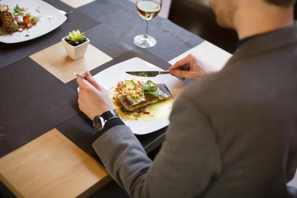 Mężczyzna jedzenie łosoś z grilla w restauracji — Zdjęcie stockowe