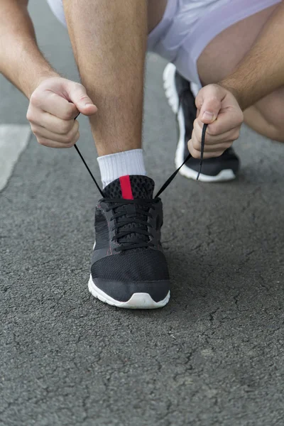 Uomo in corsa allacciatura lacci delle scarpe — Foto Stock