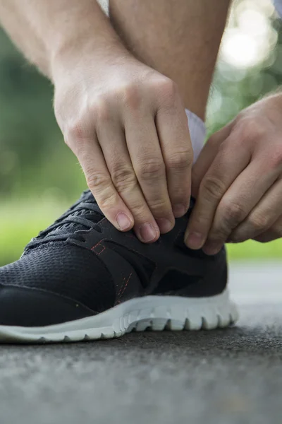 Uomo in corsa allacciatura lacci delle scarpe — Foto Stock