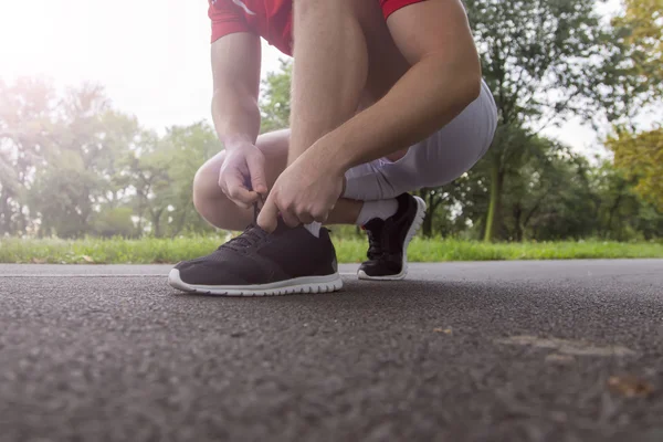 Uomo in corsa allacciatura lacci delle scarpe — Foto Stock