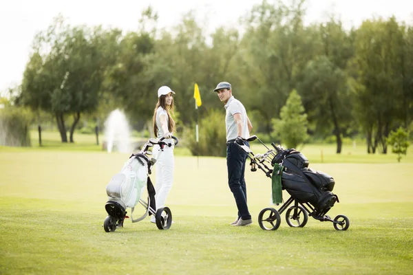 Jeune couple en voiturette de golf — Photo