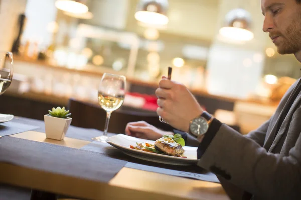 Hombre comiendo salmón a la parrilla — Foto de Stock