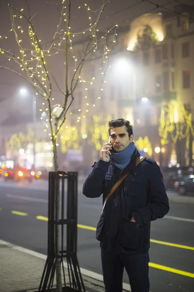 Молодой человек на улице с мобильным телефоном — стоковое фото