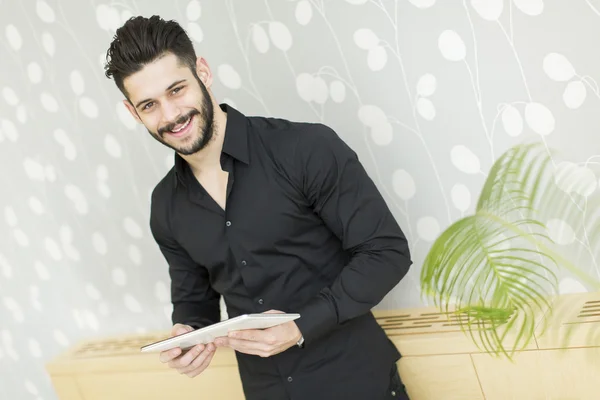 Hombre con tableta junto a la pared — Foto de Stock