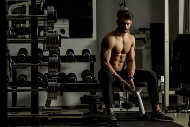 Genç adam spor salonunda antrenman yapıyor.