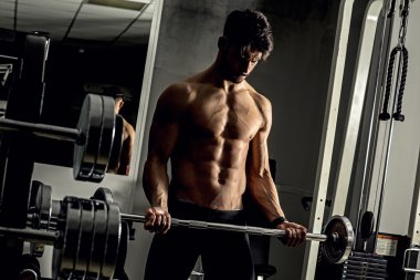 Genç adam spor salonunda antrenman yapıyor.