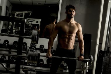 Genç adam spor salonunda antrenman yapıyor.
