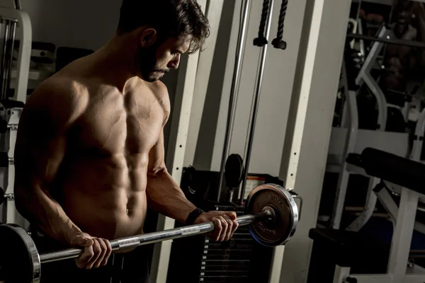 Jeune homme s'entraînant dans la salle de gym — Photo