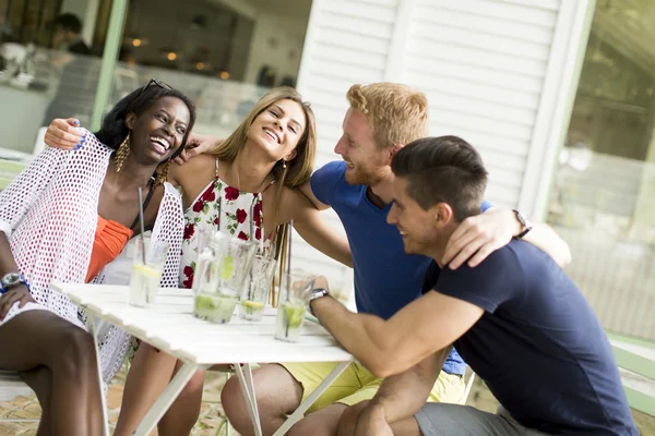 Jonge multiraciale vrienden in café — Stockfoto