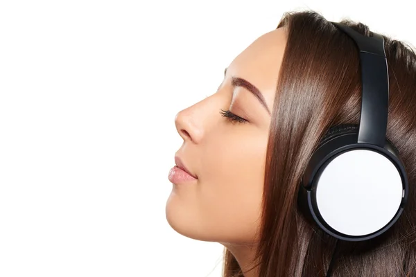 Женщина слушает музыку в наушниках с закрытыми глазами — стоковое фото
