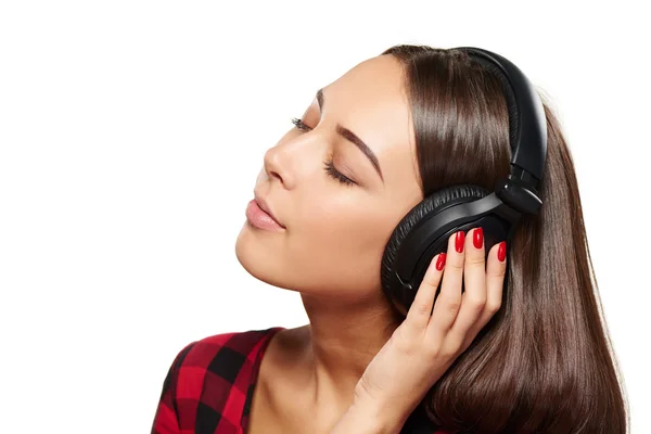 Жінка слухає, насолоджуючись музикою в навушниках із закритими очима — стокове фото