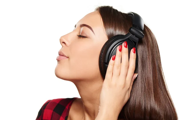 Жінка слухає, насолоджуючись музикою в навушниках із закритими очима — стокове фото