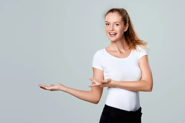 Mujer sonriente mostrando la palma de la mano abierta con espacio para copiar — Foto de Stock