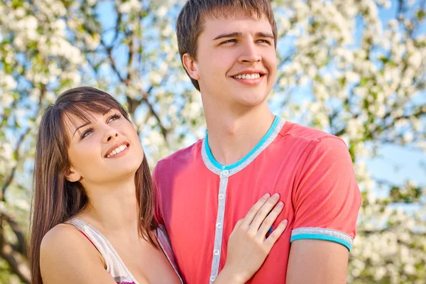 Pareja joven disfrutando en el jardín floreciente —  Fotos de Stock