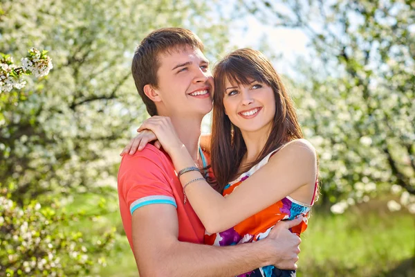 Pareja joven disfrutando en el jardín floreciente —  Fotos de Stock