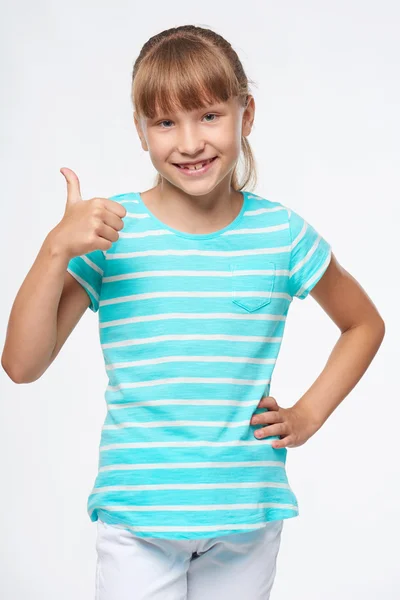 Uśmiechający się szkoły podstawowej wiek dziewczyna pokazano kciuk w górę — Zdjęcie stockowe