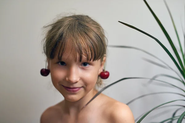 Kulaklarını bir kiraz ile küçük kız — Stok fotoğraf