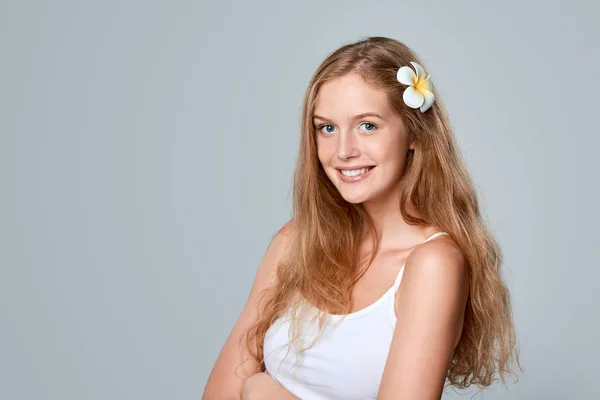 Mulher bonita jovem com flor no cabelo — Fotografia de Stock