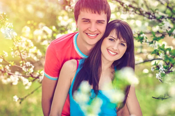 Pareja joven disfrutando en el jardín floreciente —  Fotos de Stock