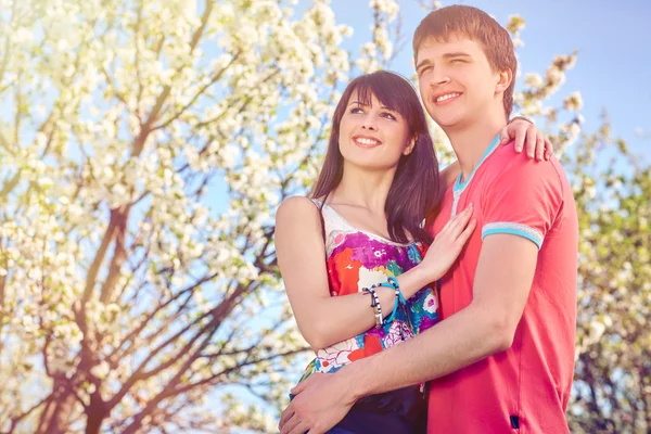 Pareja joven disfrutando en el jardín floreciente —  Fotos de Stock