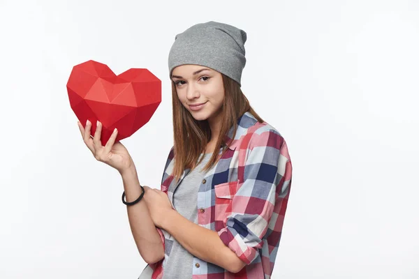 Dospívající dívka drží červený polygonální papír tvar srdce — Stock fotografie