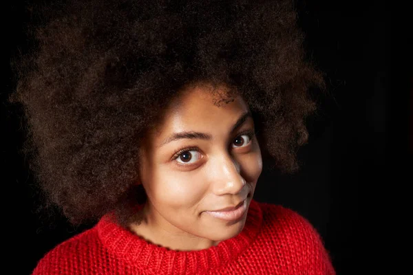 Chica de raza mixta feliz en gafas y suéter rojo, de pie con las manos dobladas, mirando a un lado — Foto de Stock