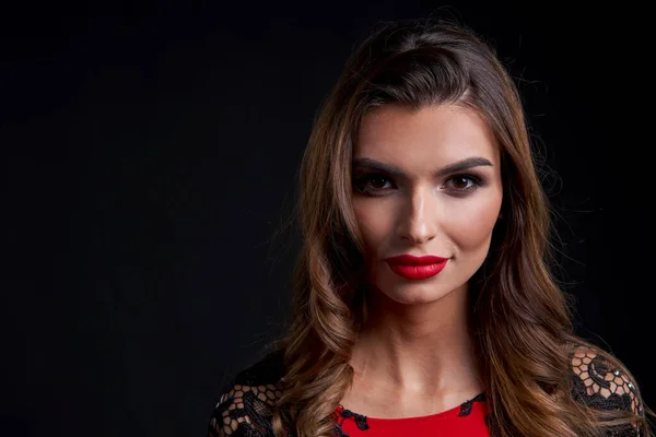 Close-up vrouw in rode jurk en rode lippen make-up kijken naar camera — Stockfoto