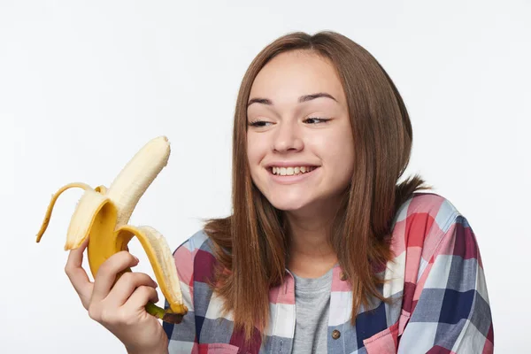 Портрет дівчинки-підлітка, що тримає наполовину очищений банан — стокове фото