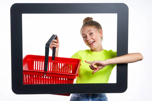 Online shopping concept. Trendy teen girl with empty shopping basket — Stock Photo, Image