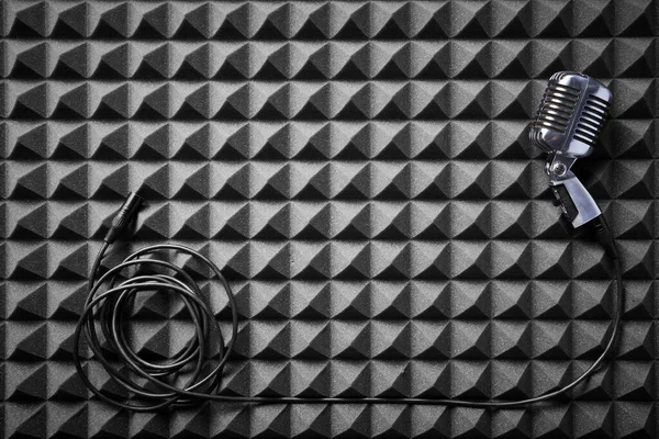 ケーブルが音響フォームパネルの背景に横たわっているレトロなマイク フラットレイ — ストック写真