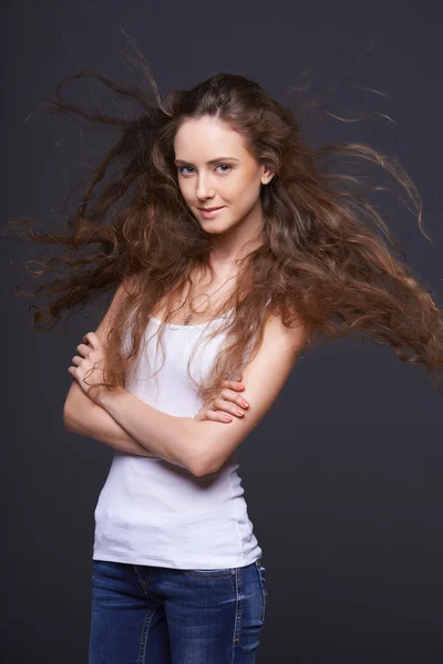 Woman posing with hair fluttering in the wind — Stock Photo, Image