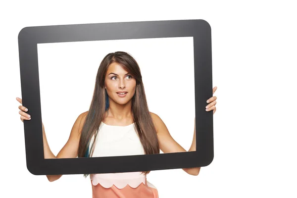Mujer mirando a un lado a través de marco de tableta — Foto de Stock