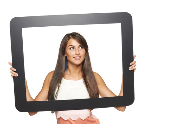 Woman looking to side through tablet frame — Stock Photo, Image