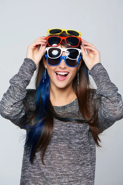 Mujer sonriente con muchas gafas de sol de colores — Foto de Stock