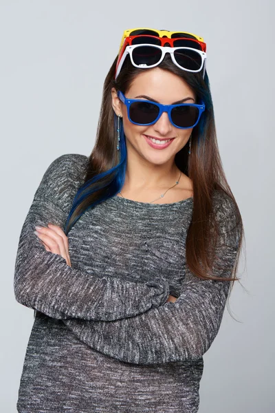 Smiling woman wearing many colourful sunglasses — Stock Photo, Image