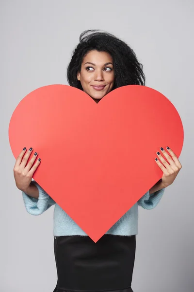 Chica sosteniendo gran forma de corazón rojo — Foto de Stock