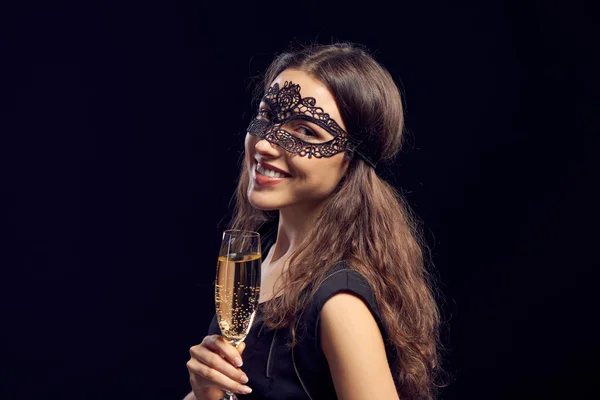 Happe vrouw in masker houden glas met champagne — Stockfoto