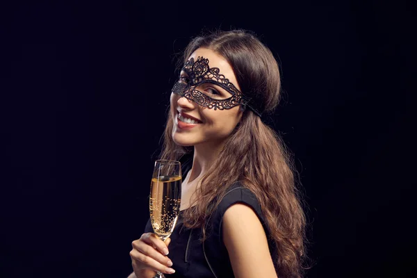 Happe kvinna i masken håller glaset med champagne — Stockfoto