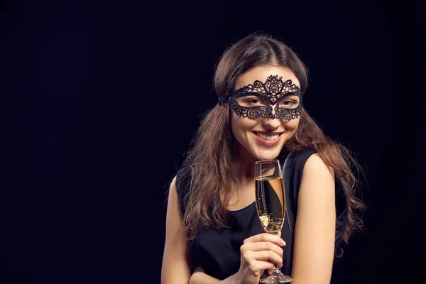 Mulher de golpe em máscara que mantém o vidro com o champanhe — Fotografia de Stock