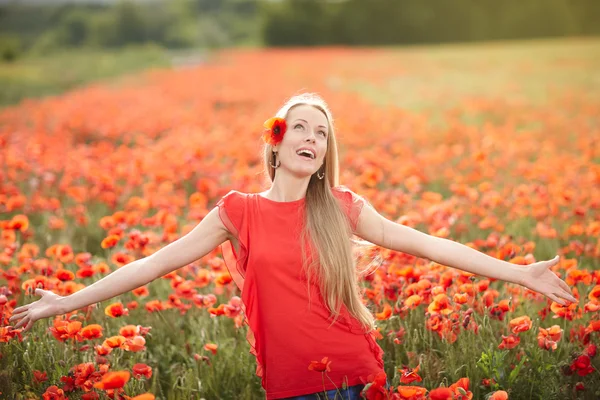 Mujer feliz en el campo de flores de amapola —  Fotos de Stock