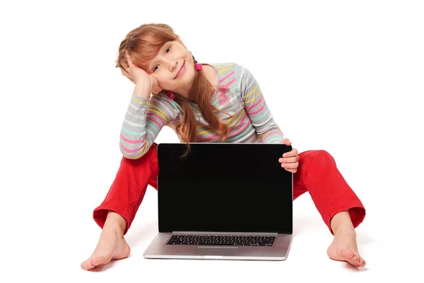小女孩坐在地上显示笔记本电脑的屏幕上 — 图库照片