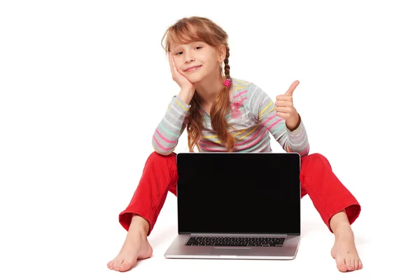 Menina sentada no chão mostrando tela do laptop — Fotografia de Stock