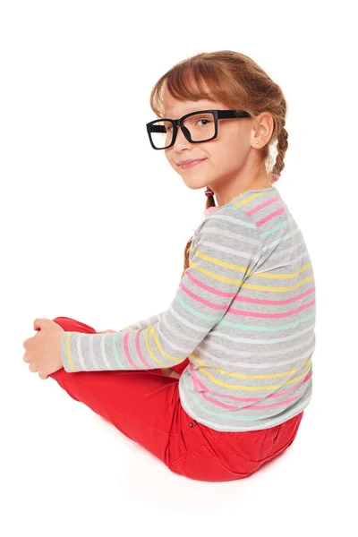 Smiling little girl sitting on floor — Stock Photo, Image