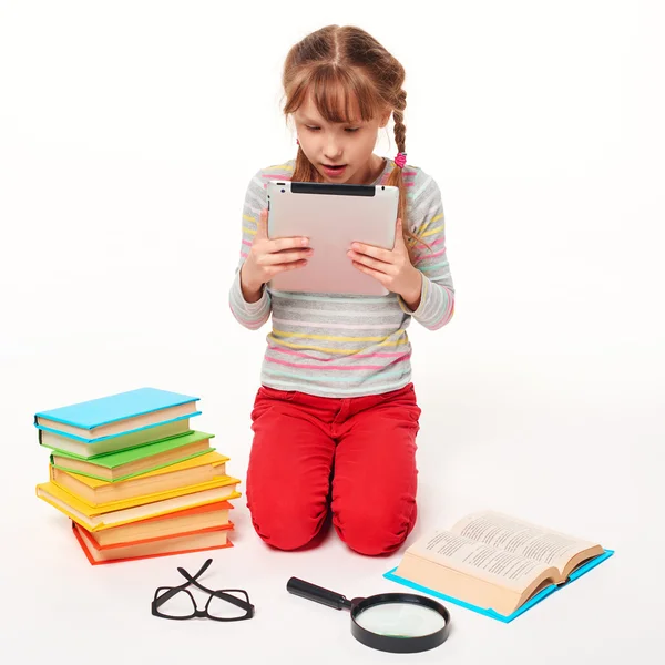 Mädchen mit vielen Büchern, die digitales Tablet lesen — Stockfoto