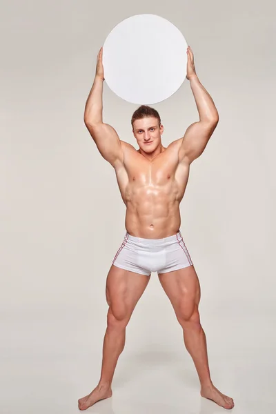 Hombre muscular elevando espacio de copia círculo en blanco — Foto de Stock