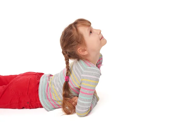 Side view of smiling child girl lying on the floor — Stock Photo, Image